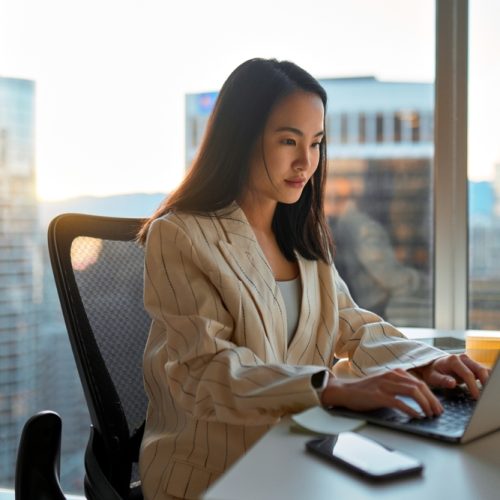 Busy,Asian,Business,Woman,Using,Laptop,In,Company,Office.,Young